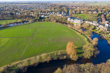 Aerial photo of the town centre of Wetherby in West Yorkshire in the UK, showing the River Wharfe at the side of soccer football pitches and houses on the other side on a sunny day in the winter © Duncan