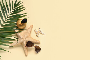 Sea star with perfume bottle, sunglasses and earrings on beige background