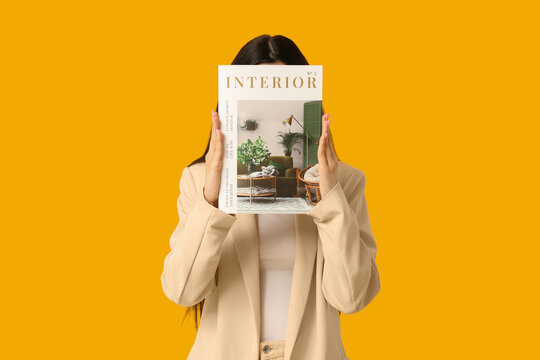 Beautiful young woman with journal on yellow background