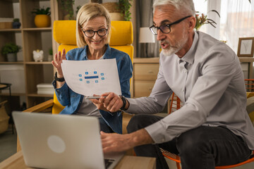 Mature man and woman work form home have consultation via video call