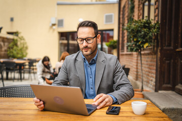 Adult man use laptop for work or browse internet in cafe restaurant