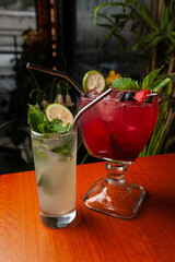 Variety of cocktails in an elegant bar decorated with bottles and sunflowers. 