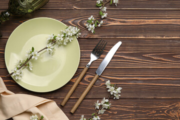 Beautiful table setting with blossoming branches on wooden background