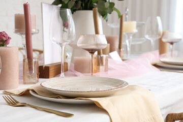 Beautiful table setting with candles for wedding celebration in room, closeup