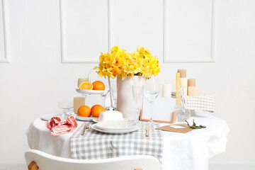 Beautiful table setting with yellow daffodils for wedding celebration in room