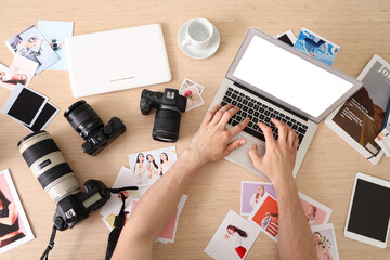 Professional male photographer with modern cameras, different photos and laptop working in studio