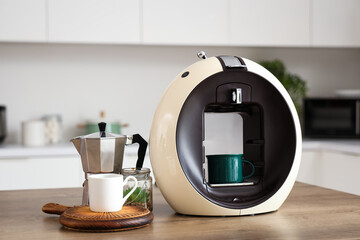 Modern coffee machine with cezve and cups on table in kitchen