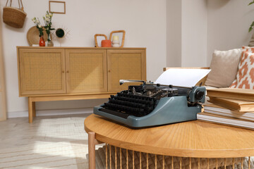 Vintage typewriter with books on table in living room, closeup