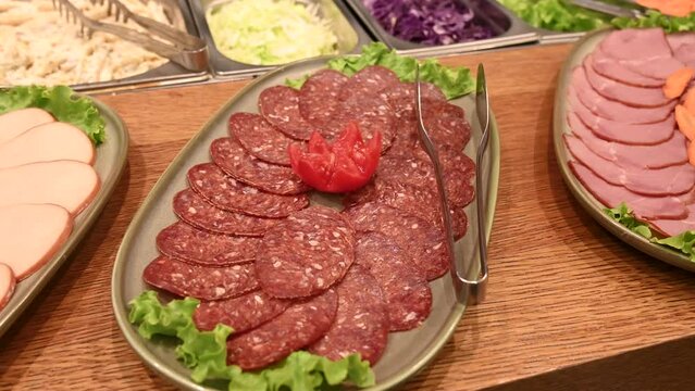 Buffet served in restaurant. Tasty food. Salami, sujuk and dried meat. Sliced salami for breakfast served in hotel. 