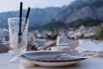 Close up of Finished Coffee Latte or Irish coffee Glass with two drinking straws, empty plate with...