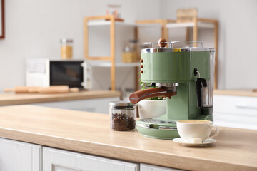 Modern coffee machine, beans and cup of espresso on wooden table in kitchen