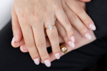 Close-up of a man's and woman's hand with a ring on the finger and a gemstone. Couple in love, man and woman holding hands. Beautiful engagement ring with a large gemstone