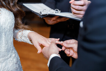 During the wedding ceremony, the groom places the ring on the bride's finger. Wedding ceremony and...