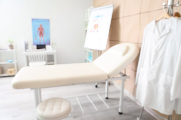 Blurred view of medical office with couch and doctor's workplace