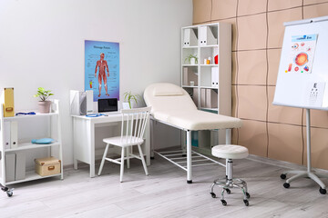 Interior of medical office with couch, shelf units and doctor's workplace