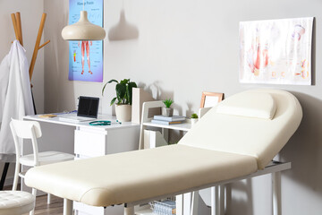 Interior of light medical office with couch and doctor's workplace