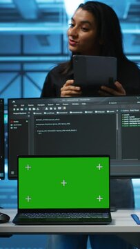 Vertical video Supervisor in server hub managing diverse team of developers using green screen laptop looking for misconfigurations. Manager coordinating experts mending data center bugs with chroma