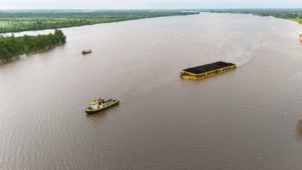 aerial view of a coal barge passing through a bridge in South Kalimantan