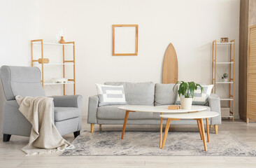 Interior of living room with sofa, tables and surfboard