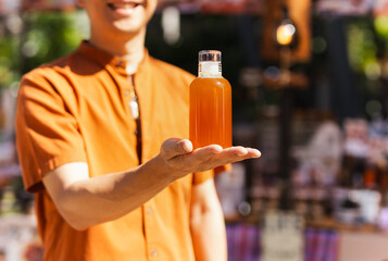 Happy man hand holding a bottle of orange juice.