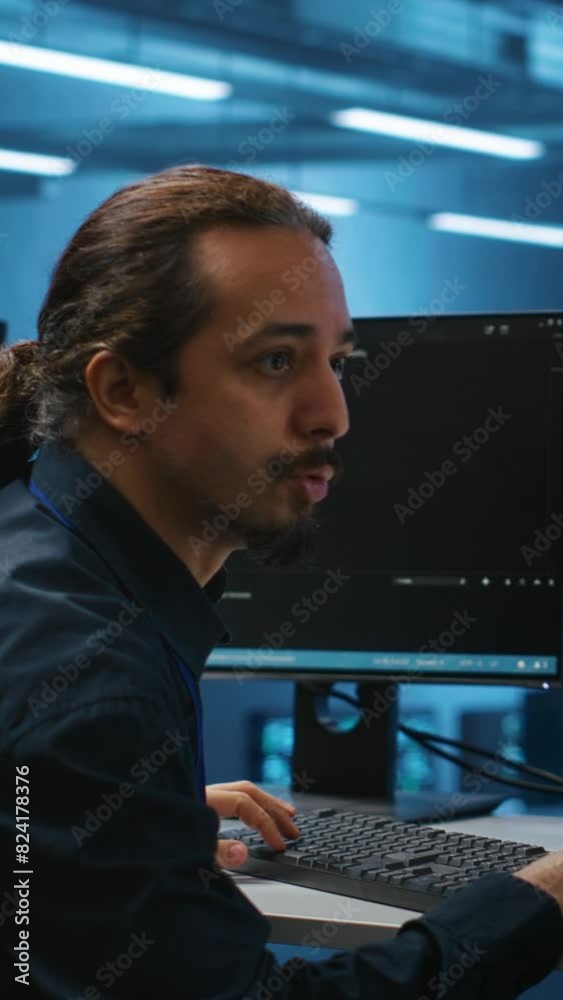 Poster vertical video engineers coding together in high tech server hub, using computers to analyze data, e
