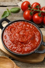 Homemade tomato sauce in bowl on wooden table, closeup