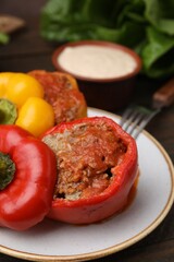 Delicious stuffed bell peppers served on wooden table, closeup