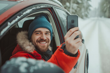 Young man in a car in the winter taking a selfie with her phone.