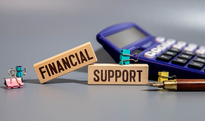 FINANCIAL SUPPORT text on wooden block, blue background