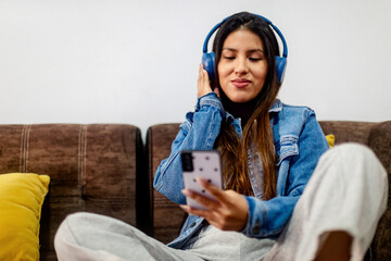 Smiling Woman Immersed in Joyful Music with Blue Headphones, Copyspace