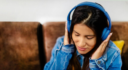 Listening to Music with Blue Headphones and Denim Jacket.copyspace
