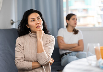 Portrait of two disgruntled girlfriends feeling outraged, quarreling and emotionally gesturing at home