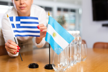 Little flag of Argentina on table with bottles of water and flag of Greece put next to it by...