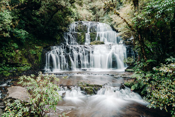 Obraz premium Tiered Waterfall Flowing in Forest Long Exposure Slow Shutter
