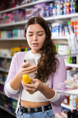 Female shopper scanning a QR code using a mobile phone in a cosmetics store