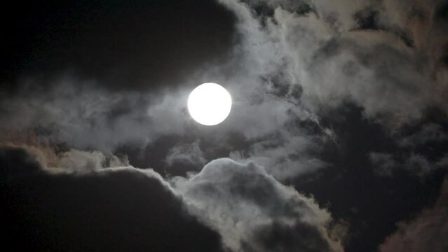 NORMAL SPEED VIDEO OF DRAMATIC NIGHT SKY WITH FULL MOON AMONG THE DARK CLOUDS