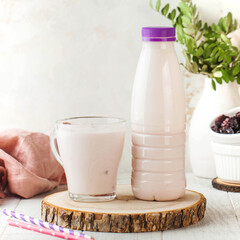 Berry-flavored drinking yogurt served in a glass and a matching bottle