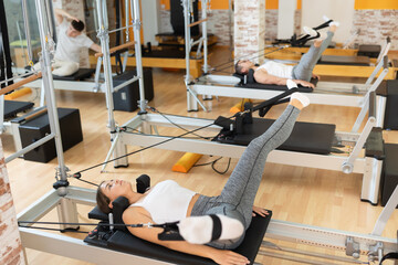 Young girl engaging in rehabilitation exercises targeting leg and core muscles using straps on...