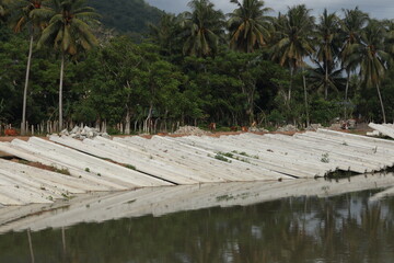Piles of concrete slabs on the riverbank in Indonesia.