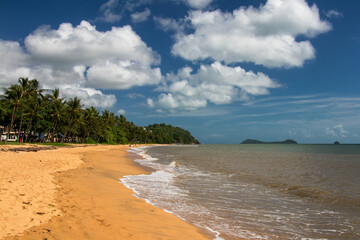 Experience the pristine beauty of Trinity Beach in Far North Queensland, Australia, where golden sands meet azure waters under a tropical sun, inviting relaxation and coastal bliss.