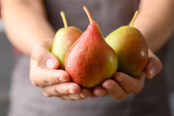 Fresh pear fruit holding by woman hand, Healthy eating