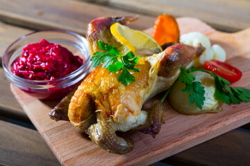 Poultry baked in oven with cranberry sauce and grilled vegetables served on wooden board