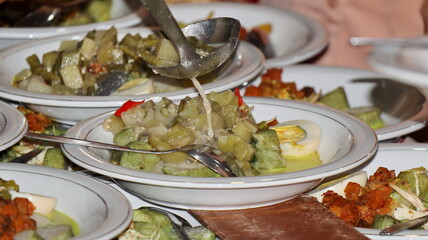 Lontong Sayur, served with chicken, balado potatoes, vegetables lodeh eggplant coconut milk and crackers