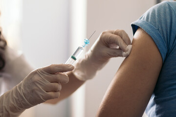 doctor cleaning arm with cotton before vaccination