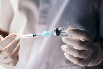 injecting injection vaccine vaccination medicine against covid-19 into a syringe. Close-up