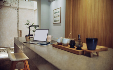 Comfortable workplace on counter bar in cafe withe computer laptop, mobile put on note book, coffee cup and coffee making equipment in foreground, taking a break after work concept