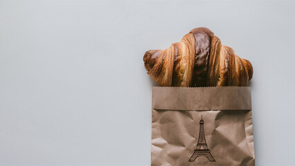 Freshly baked French buttery flaky croissants in brown paper bag on white background. Minimalist creative food banner with copy space