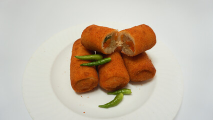Risoles, traditional snack form Indonesia. It filled with carrot, potato, chicken and other vegetables rolled in breadcrumbs then deep fried, served with green chili on a plate on white background.