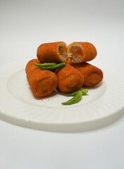 Risoles, traditional snack form Indonesia. It filled with carrot, potato, chicken and other vegetables rolled in breadcrumbs then deep fried, served with green chili on a plate on white background.