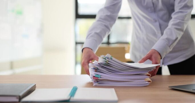 Woman manager secretary or intern at desk is overloaded with paperwork